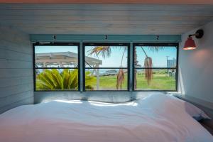 a bed in a room with a large window at Hotel Ocean BUS Shirahama in Shioura