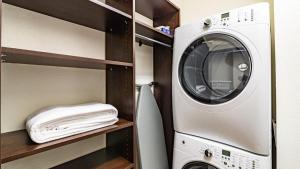 - un lave-linge et un sèche-linge dans une petite pièce dans l'établissement Landing Modern Apartment with Amazing Amenities (ID8283X49), à Englewood