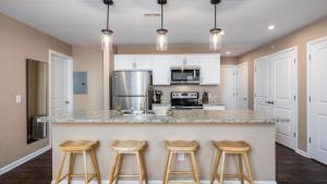 una cocina con una encimera grande con taburetes. en Landing Modern Apartment with Amazing Amenities (ID8358X13), en Columbus