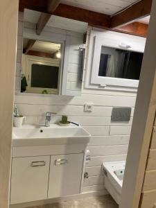 a white bathroom with a sink and a tub at Lakeside Hideaway Cabin in Bursa