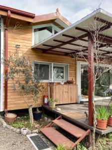 een houten huis met een veranda en een terras bij Lakeside Hideaway Cabin in Bursa