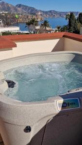 a jacuzzi tub with a view of the water at Apartamentos Latin in Nerja