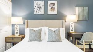 Cette chambre comprend un lit blanc avec deux lampes et un bureau. dans l'établissement Landing Modern Apartment with Amazing Amenities (ID9577X84), à Charlotte