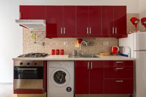 a kitchen with red cabinets and a washing machine at New Flat Between The Vatican & Piazza del Popolo in Rome