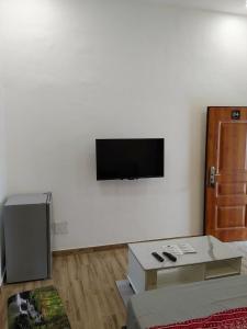 a living room with a flat screen tv on a wall at LES 9 PLURIELLES - Studio 4 in Palimé
