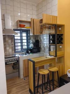 cocina con armarios de madera y encimera de madera en LES 9 PLURIELLES - Studio 4 en Palimé