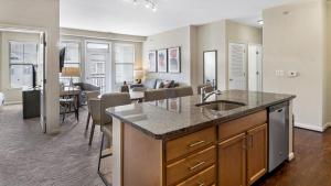 a kitchen with a sink and a living room at Landing Modern Apartment with Amazing Amenities (ID8354X41) in Leesburg