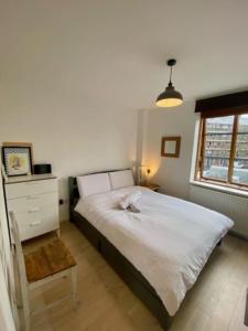 a bedroom with a bed and a dresser and a window at Beautiful canal-view apartment in London