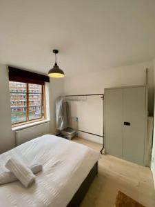 a bedroom with a large white bed and a window at Beautiful canal-view apartment in London
