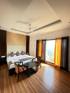 a bedroom with a bed and a table in a room at Hotel Kaithli Hills Shimla in Shimla