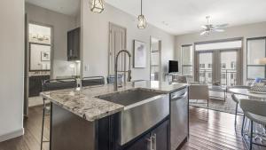 cocina con fregadero y sala de estar. en Landing Modern Apartment with Amazing Amenities (ID9564X38) en Houston