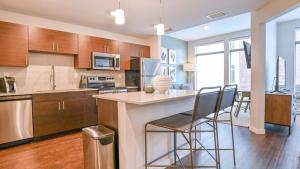 una cocina con una isla con taburetes en Landing Modern Apartment with Amazing Amenities (ID8092X98) en Orlando