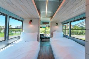 two beds in a room with windows at Hotel Ocean BUS Shirahama in Shioura