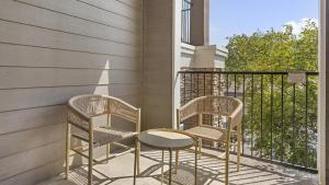 2 Stühle und ein Tisch auf dem Balkon in der Unterkunft Landing Modern Apartment with Amazing Amenities (ID8382X95) in Tulsa