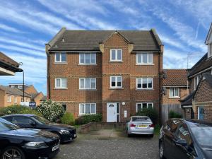 una casa de ladrillo con coches aparcados delante de ella en The Hackney Place - Spacious 1BDR Flat en Londres