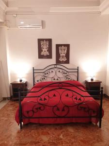 a bedroom with a red bed with two night stands at Arco del vescovo 2 in Acireale