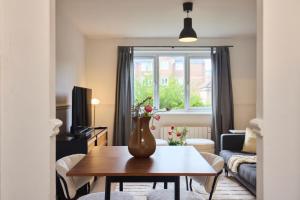 a living room with a vase of flowers on a table at The Hackney Place - Spacious 1BDR Flat in London