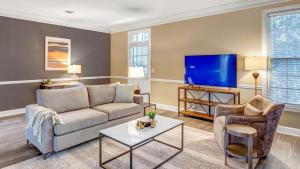 een woonkamer met een bank en een tv bij Landing Modern Apartment with Amazing Amenities (ID9248) in Nashville