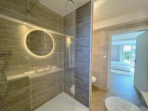 ein Bad mit einer Dusche, einem Waschbecken und einem Spiegel in der Unterkunft Les Fontaines d'O in Castelnau-dʼEstrétefonds