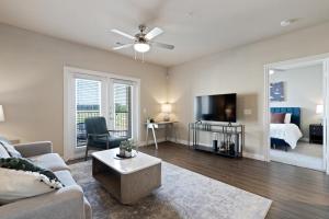 a living room with a couch and a room with a bed at Landing Modern Apartment with Amazing Amenities (ID3876) in Carrollton