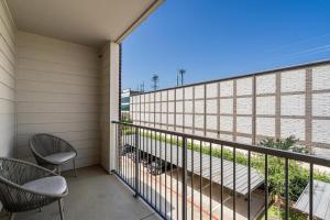 balcón con 2 sillas y vistas a un edificio en Landing Modern Apartment with Amazing Amenities (ID3876) en Carrollton