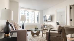 sala de estar con sofá y mesa en Landing Modern Apartment with Amazing Amenities (ID3117X83) en Nueva York
