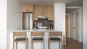 a kitchen with a counter with four chairs at it at Landing Modern Apartment with Amazing Amenities (ID3117X83) in New York