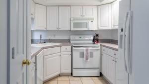 eine weiße Küche mit weißen Geräten und weißen Schränken in der Unterkunft Landing Modern Apartment with Amazing Amenities (ID7433X30) in Indianapolis
