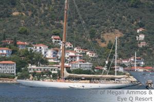 a sail boat in the water next to a city at Eye Q Resort in Megali Ammos