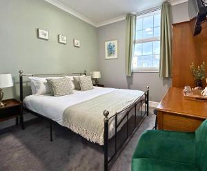 a bedroom with a bed and a desk and a chair at The Windmill Hotel in Lincolnshire