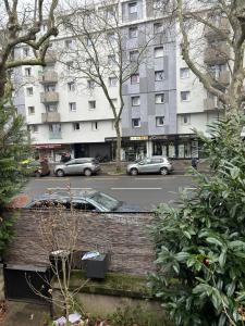 a building with cars driving down a city street at Pavillon Tawfik 1 à 4 personnes chez l’habitant in Bagneux
