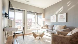 ein Wohnzimmer mit einem Sofa und einem Glastisch in der Unterkunft Landing Modern Apartment with Amazing Amenities (ID5151X99) in Tower Grove