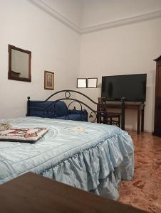 a bedroom with a bed and a flat screen tv at Arco del vescovo 2 in Acireale