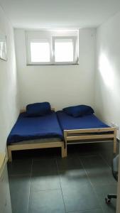 a bedroom with a bed with blue sheets and a window at Nina Zimmer in Heilbronn Zentrum in Heilbronn