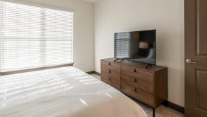 - une chambre avec un lit et une télévision sur une commode dans l'établissement Landing Modern Apartment with Amazing Amenities (ID8060X85), à Louisville
