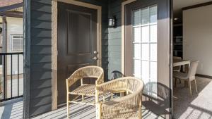 - une terrasse couverte avec 2 chaises et une porte dans l'établissement Landing Modern Apartment with Amazing Amenities (ID8060X85), à Louisville