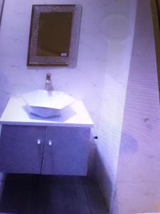 a bathroom with a white sink and a mirror at Sanzak hotel and apartments in Lagos