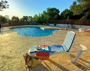 a lawn chair sitting in front of a swimming pool at Casa Mariseta y Tonet, naturaleza a 2 km del mar in Calpe