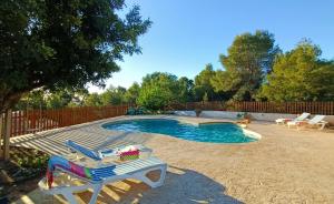 una piscina con terraza y 2 sillas junto a ella en Casa Mariseta y Tonet, naturaleza a 2 km del mar en Calpe