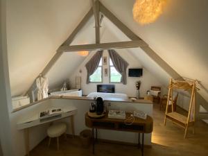 een slaapkamer met een bed en een bureau op zolder bij L'Orée du Mont in Pontorson