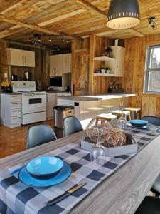uma cozinha com uma mesa com pratos azuis em Chalet Chic Shack - Un endroit paisible em Frampton