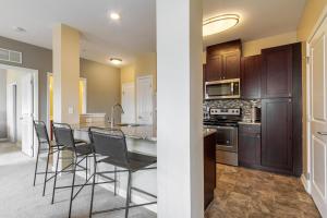 eine Küche mit einem Tisch und Stühlen im Zimmer in der Unterkunft Landing Modern Apartment with Amazing Amenities (ID2286) in Ellicott City