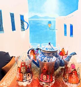 a table topped with four cups and a tea pot at The Sidibou Said Story in Sidi Bou Saïd