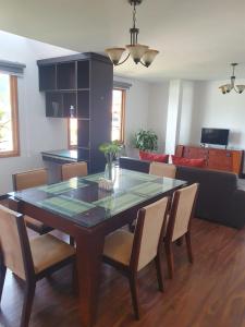 a dining room with a glass table and chairs at Adelita Departamento Loja in Loja +6 photos