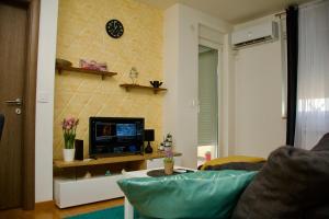 uma sala de estar com um sofá e uma televisão em Yellow em Belgrado