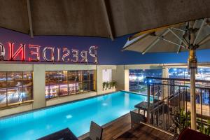 a swimming pool on the roof of a building with a sign at PRESIDENCY AIRPORT HOTEL in Cochin