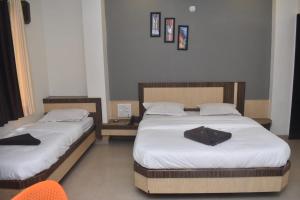 Rúm í herbergi á HOTEL SAI VISHVA KARMA