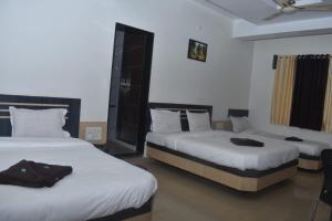 Rúm í herbergi á HOTEL SAI VISHVA KARMA