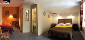 a hotel room with two beds and a hallway at cit'hotel Hotel Las Cigalas in Villeneuve-lès-Béziers