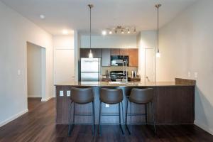 uma cozinha com um bar com bancos em Landing Modern Apartment with Amazing Amenities (ID2977X82) em Austin